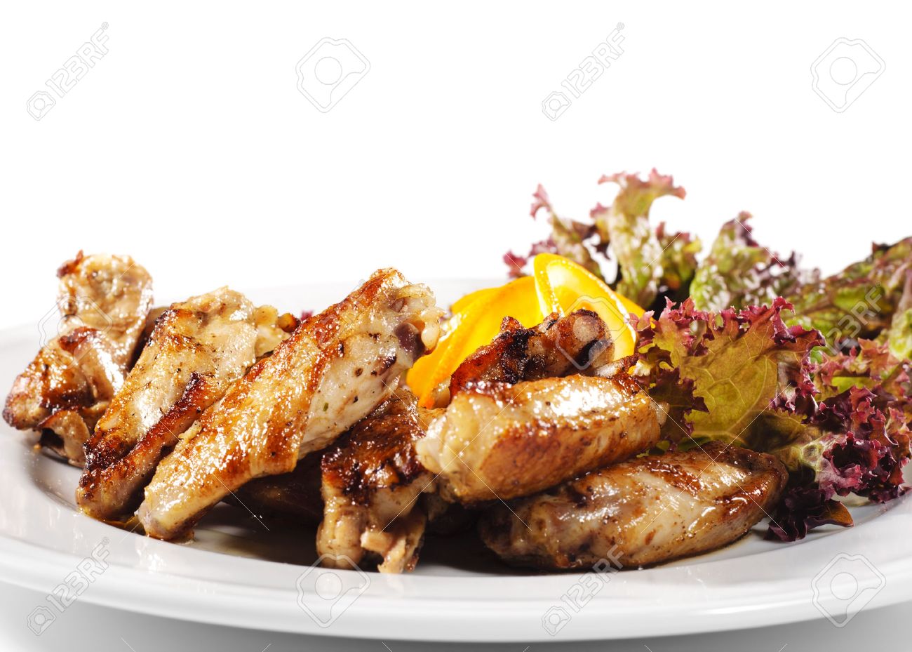 5123204-Hot-Meat-Dishes-Fried-Chicken-Wings-with-Orange-Slice-and-Vegetable-Leaf-Stock-Photo